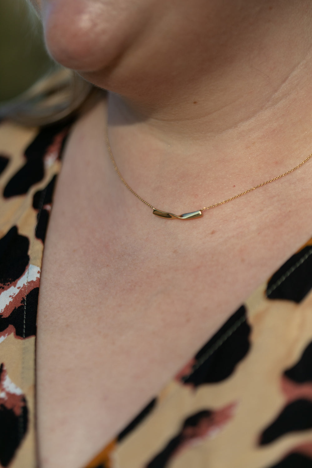 a close up of a plus size woman's neck wearing a gold twist necklace #color_gold