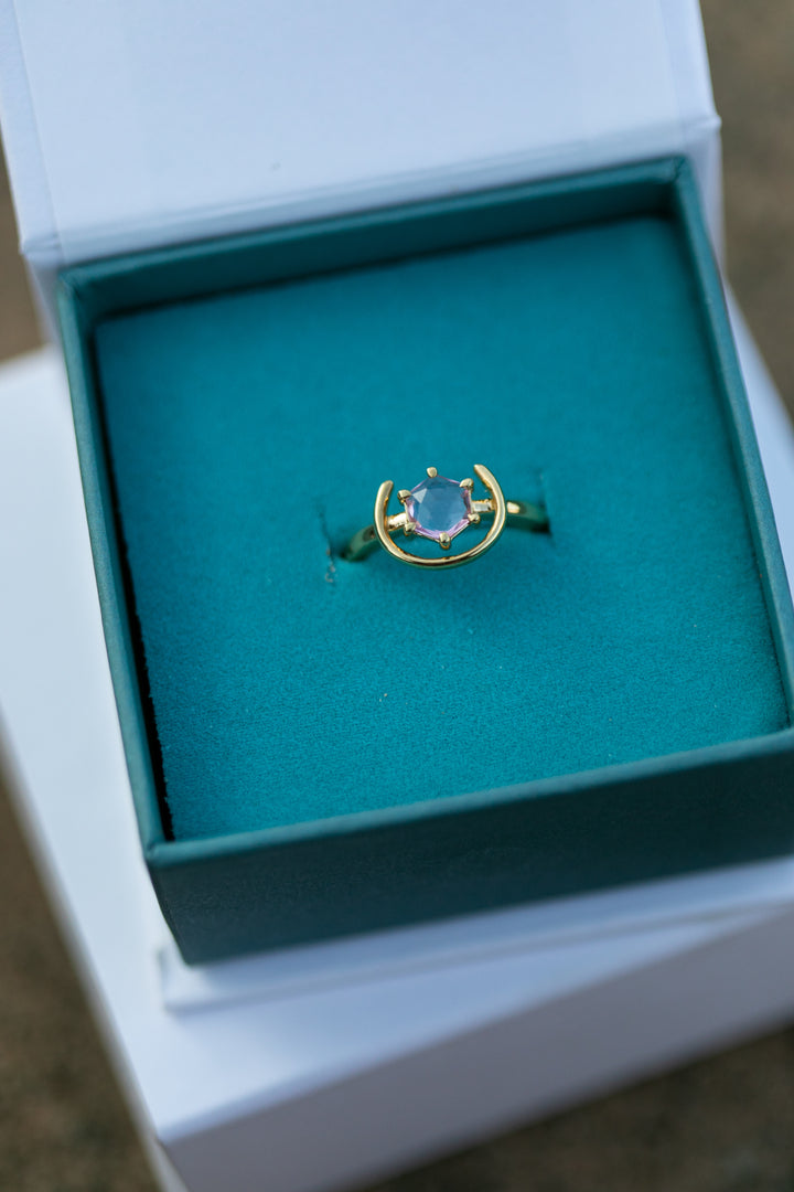 a detail image of our gold and pink spinel gemstone ring sitting in a teal and white Chouette Designs branded box. Plus size and size inclusive ring.