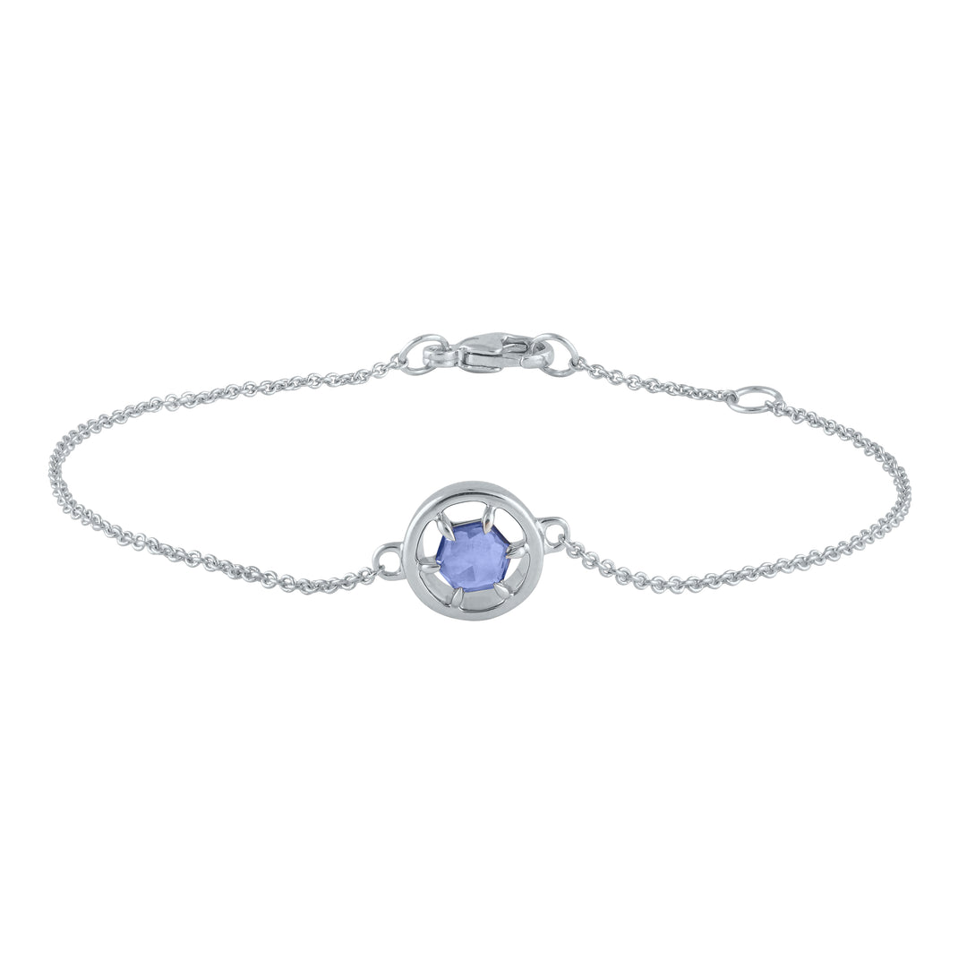 a detailed image of the gemstone bracelet in silver with rose cut hexagonal tanzanite. The tanzanite is set in a silver circle on a delicate silver chain.