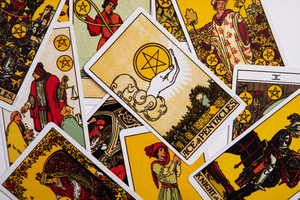 several Tarot cards lay face up with the Ace of Pentacles most visible