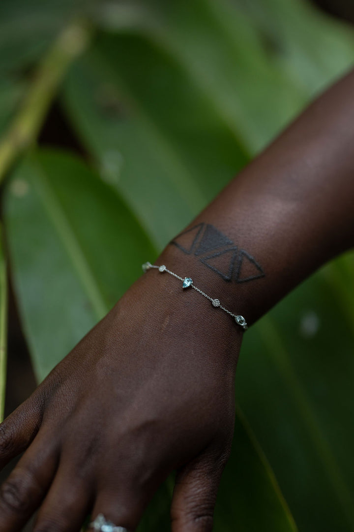 the Monteverde bracelet in silver on a model. Green tropical foliage is visible in the background #color_silver