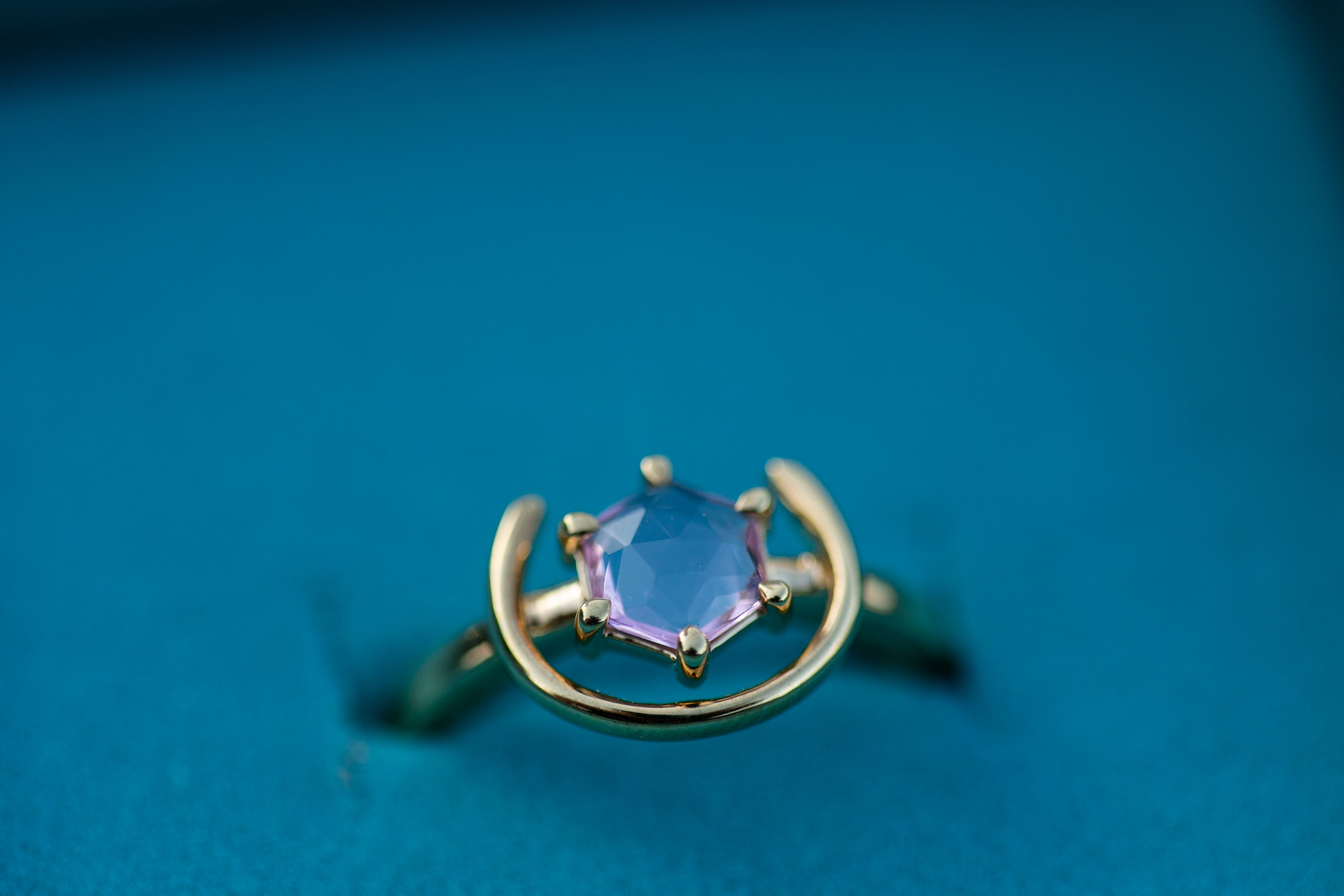 a very close up shot of the gemstone ring in gold and pink spinel sitting in our teal Chouette Designs branded box. Plus size, size inclusive ring.
