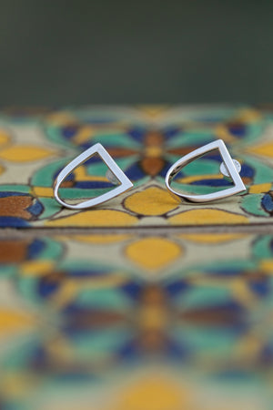 Open image in slideshow, a pair of silver twist earrings sit atop a colorful Spanish style tile.

