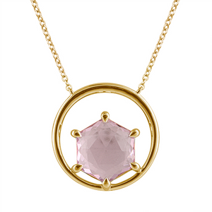 a detail shot of the gemstone pendant in gold with rose cut hexagonal spinel. The spinel is prong set in a circle of gold, set on a delicate gold chain.
