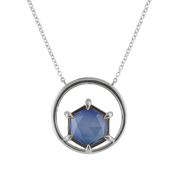 a detail shot of the gemstone pendant in silver with rose cut hexagonal tanzanite. The tanzanite is prong set in a circle of silver, set on a delicate silver chain.
